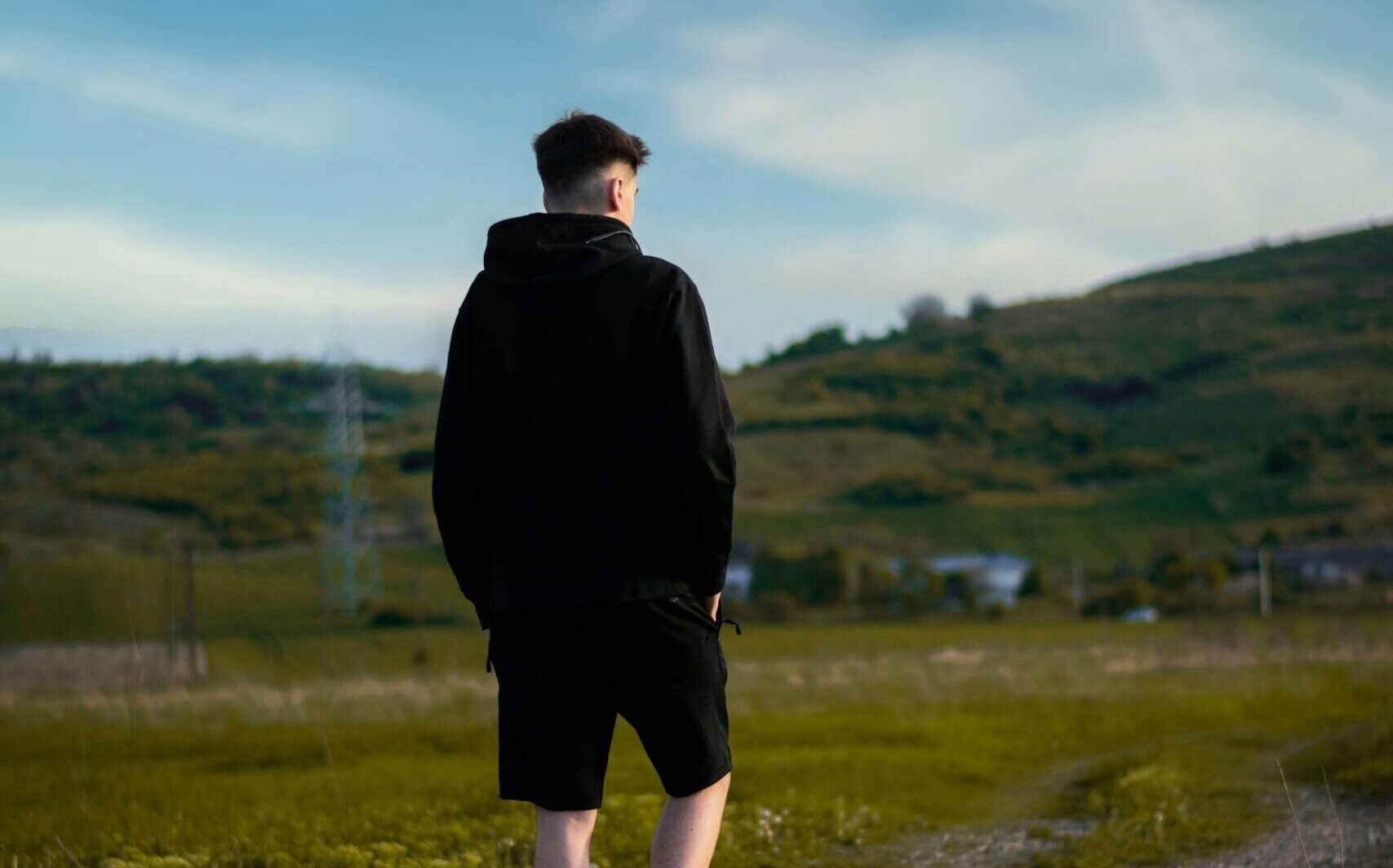 Young boy walking on country lane
